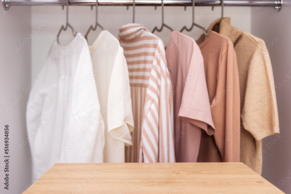 Mockup against background of wardrobe with clothes in neutral colors, copy paste
