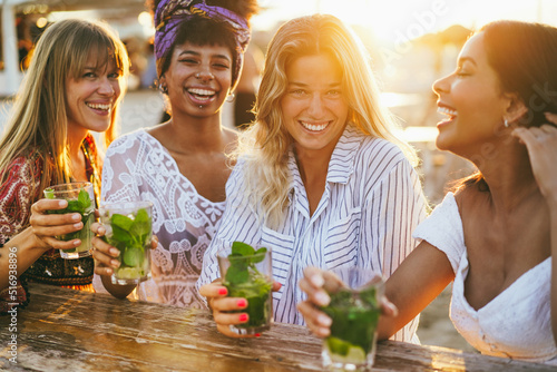 Photography Happy girls having fun drinking cocktails at bar on the beach - Soft focus on ri