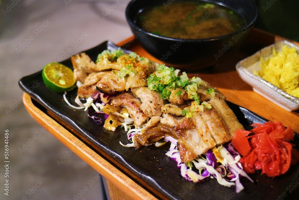 Freshly cooked Japanese style grilled pork belly on black long plate Freshly cooked Japanese style grilled pork belly on black long plate