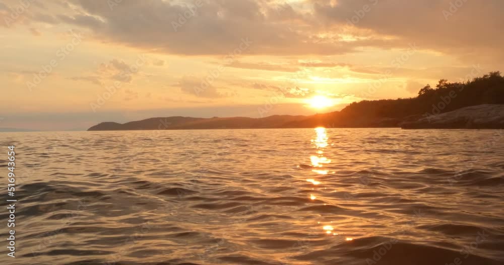 Majestic summer sunset or sunrise landscape over seascape horizon. Sunlight reflection on water surface. Golden hours lights at rocky beach. 4K footage. Majestic summer sunset or sunrise landscape over seascape horizon. Sunlight reflection on water surface. Golden hours lights at rocky beach. 4K footage.