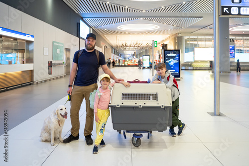 Obraz na płótnie Family with big dog in airport. Safe travel with domestic animals by plane or train. Transportation container for big pets. Copy space. w salonie