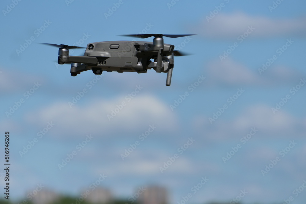 Gray quadcopter in flight. Photo-video aerial photography. Gray quadcopter in flight. Photo-video aerial photography.