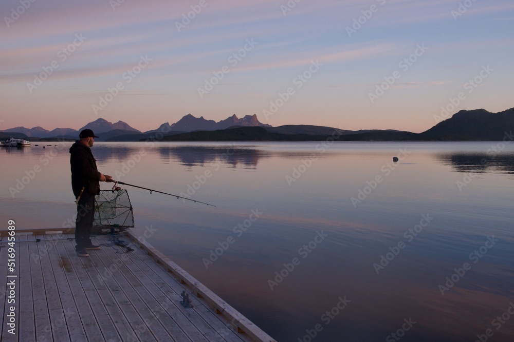 Silhouette of a fisherman fishing in sunset time on the open sea