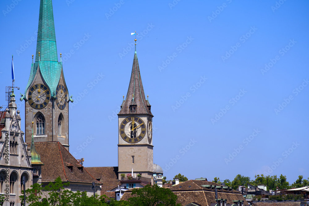 Fototapeta premium Medieval old town of Zürich with church towers of Women's Minster and St. Peter on a sunny hot summer day. Photo taken June 19th, 2022, Zurich, Switzerland.