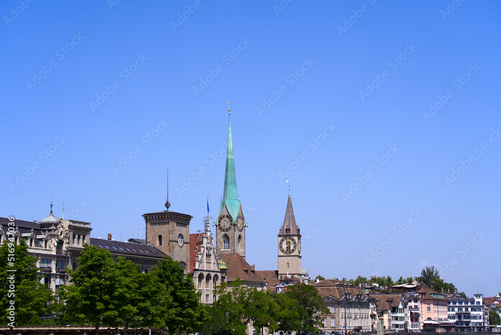 Fototapeta premium Medieval old town of Zürich with church towers of Women's Minster and St. Peter on a sunny hot summer day. Photo taken June 19th, 2022, Zurich, Switzerland.