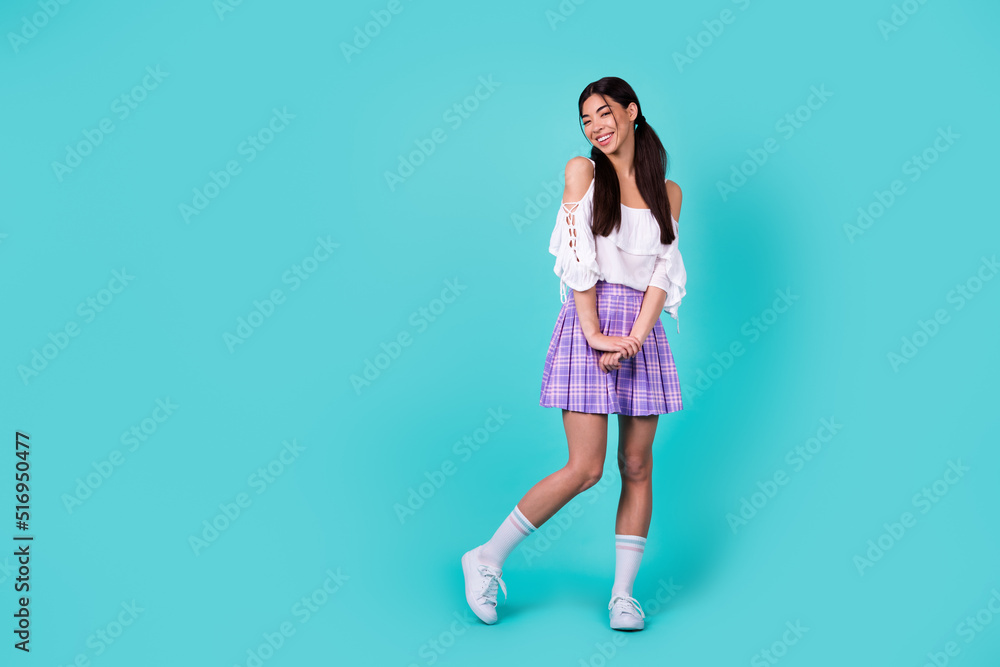 Full size photo of stunning cheerful vietnamese lady posing empty space isolated on shine teal color background Full size photo of stunning cheerful vietnamese lady posing empty space isolated on shine teal color background