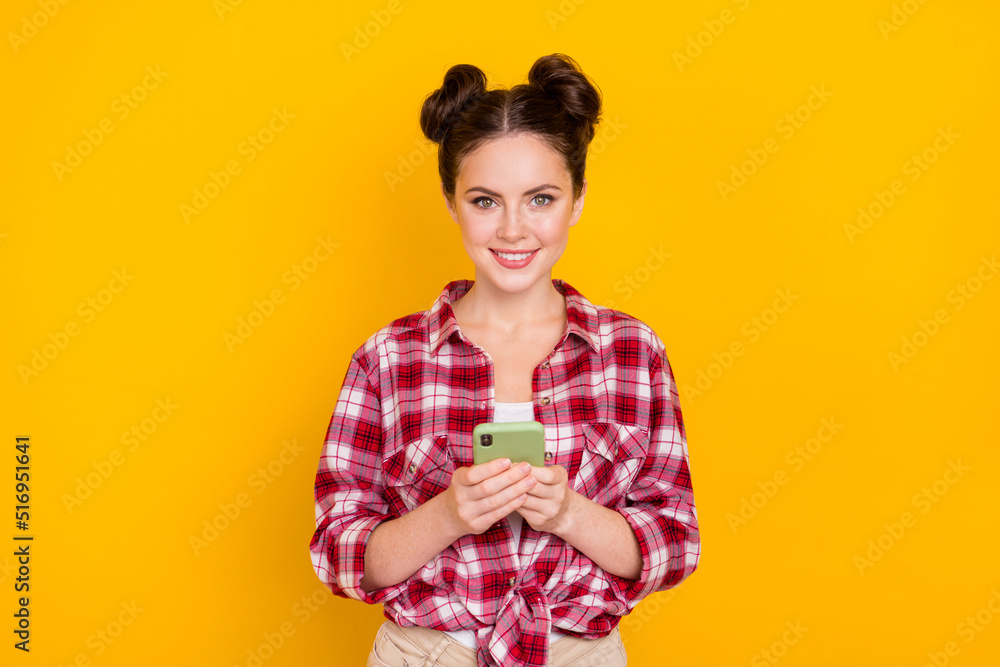 Portrait of positive pretty girl hold telephone toothy smile look camera isolated on yellow color background Portrait of positive pretty girl hold telephone toothy smile look camera isolated on yellow color background