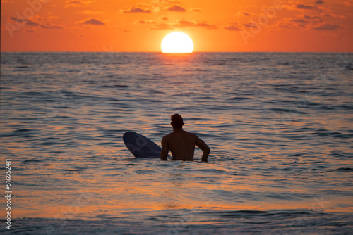 Obraz na płótnie Silhouette of Surfer waiting on the line up for a wave at sunrise or sunset w salonie