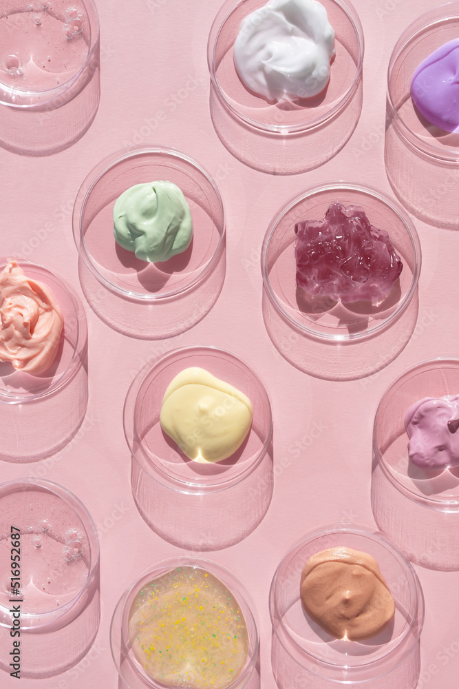 Multicolored textures of cream, scrub, serum and gel in Petri dishes on a pink background. Concept of cosmetics laboratory researches. Smear of skincare cosmetics product. Wellness and beauty concept Multicolored textures of cream, scrub, serum and gel in Petri dishes on a pink background. Concept of cosmetics laboratory researches. Smear of skincare cosmetics product. Wellness and beauty concept
