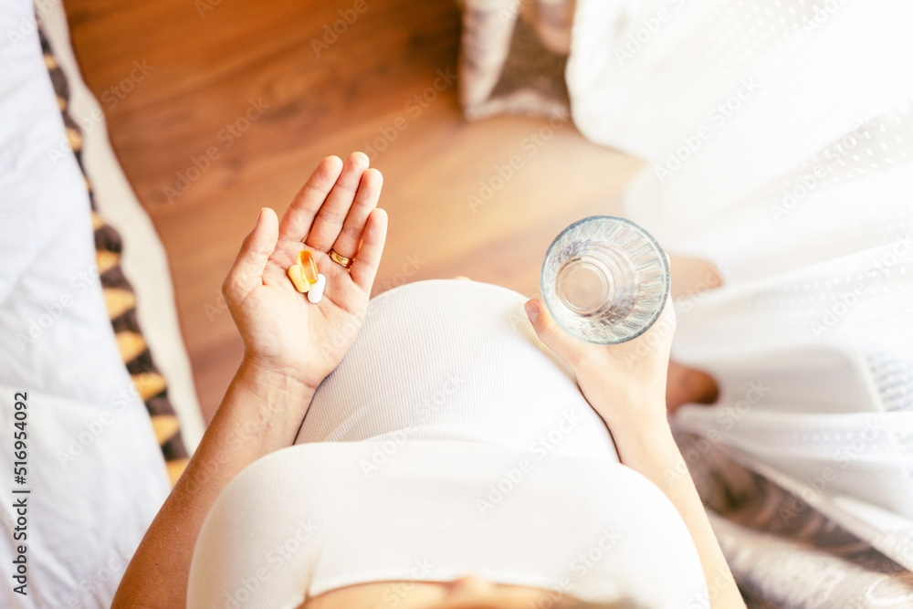Pregnant woman pills vitamin. Happy smiling woman taking pill with supplement vitamin Omega 3. Vitamin D, E, A Fish Oil Capsules. Pregnant woman pills vitamin. Happy smiling woman taking pill with supplement vitamin Omega 3. Vitamin D, E, A Fish Oil Capsules.