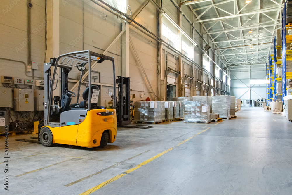 Interior of a modern warehouse with forklifts. Pallet stacker truck equipment at warehouse. Forklift loader