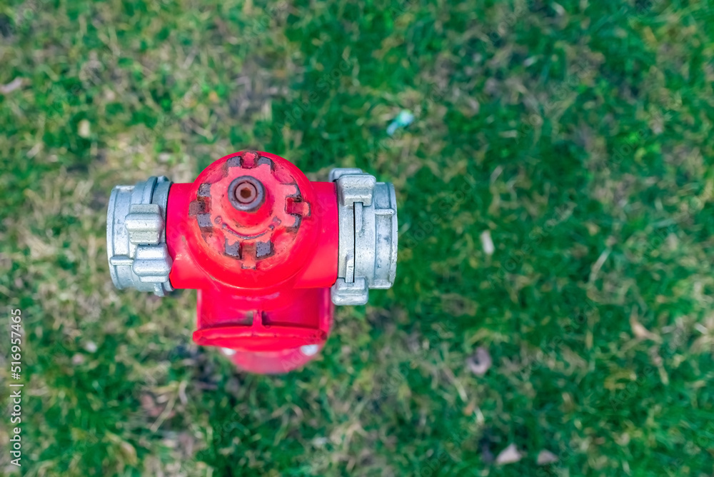 Single red fire hydrant on green lawn.Autumn,spring,summer day.Copy space.Top view. Single red fire hydrant on green lawn.Autumn,spring,summer day.Copy space.Top view.