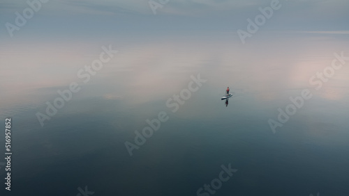 Stand up paddleboarding on the endless water surface