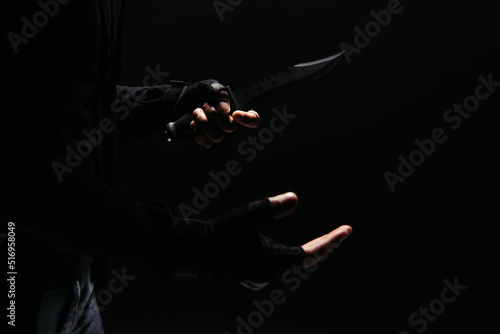 Cropped view of african american bandit in gloves holding knife isolated on black