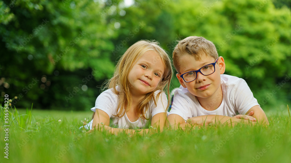 children lying on the green grass in the Park. The interaction of the children children lying on the green grass in the Park. The interaction of the children