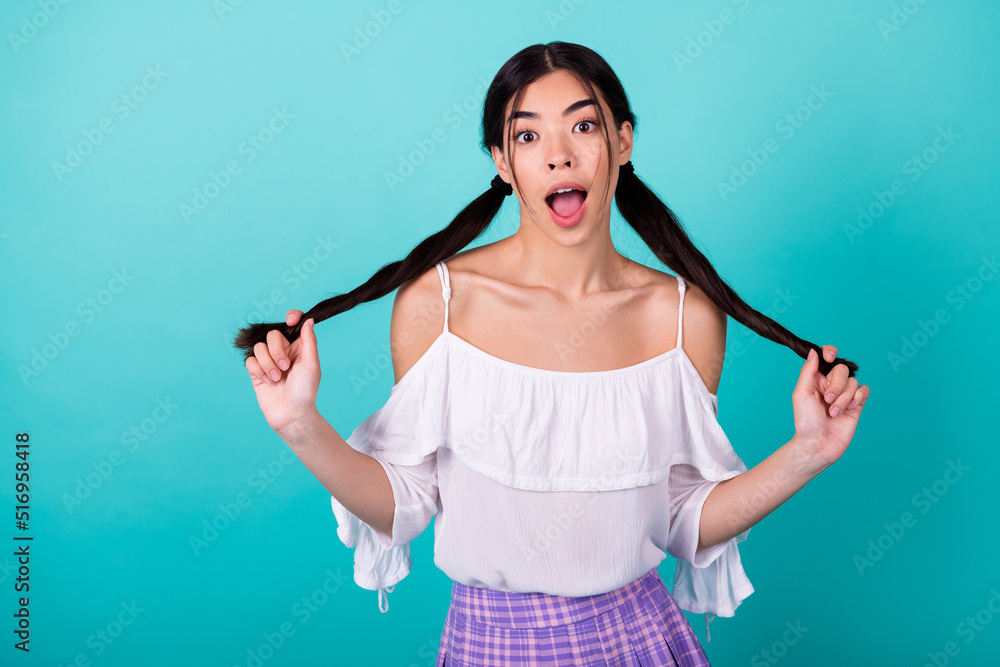 Photo of astonished crazy malaysian lady hands hold tails open mouth isolated on turquoise color background Photo of astonished crazy malaysian lady hands hold tails open mouth isolated on turquoise color background