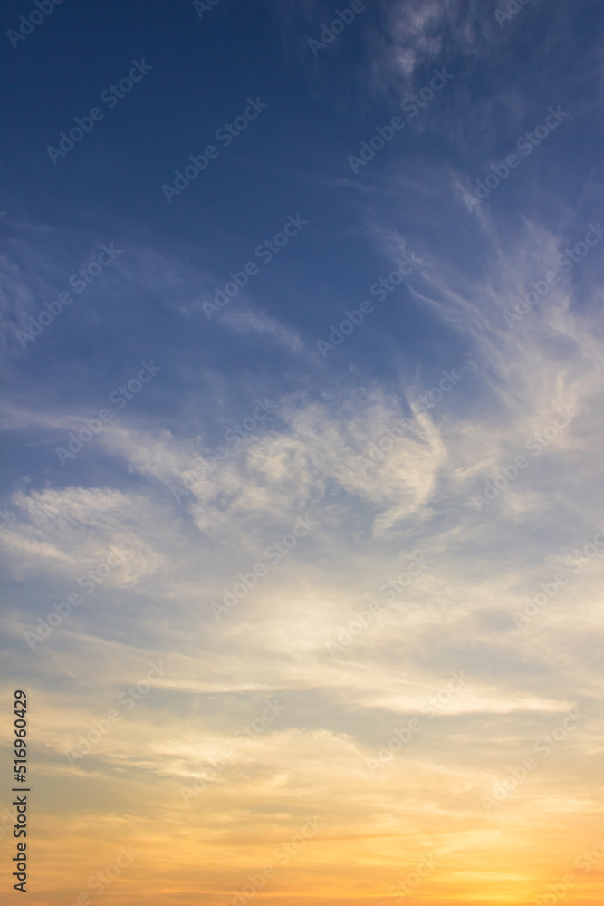 Sunset sky clouds vertical in the evening on summer season with orange, yellow, sunlight on blue sky background 