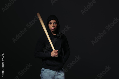 African american hooligan holding baseball bat isolated on black