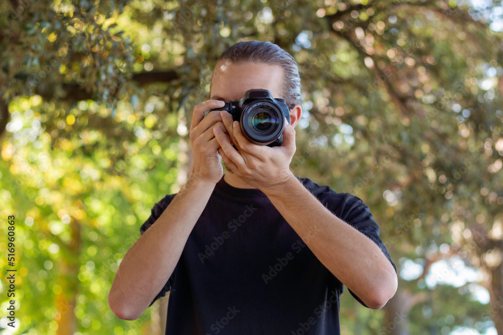 attractive photographer man shooting at the forest o the park attractive photographer man shooting at the forest o the park
