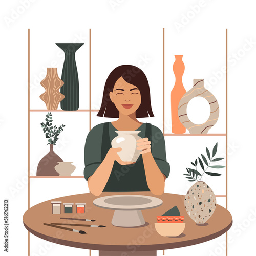 Woman decorating pot working at ceramic studio.