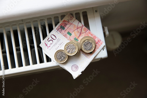 Cost of living crisis. Money on a home radiator heater. Rising cost of energy and bills