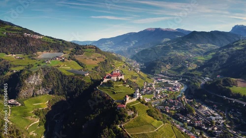 Klausen, Italy - 4K flying towards Saben Abbey (Monastero di Sabiona) by Chiusa (Klausen) commune northeast of the city of Bolzano and South Tyrol Dolomites at background on a sunny summer day 