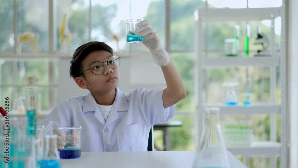 Asian scientist boy stretched arms during in chemistry class in lab Asian scientist boy stretched arms during in chemistry class in lab