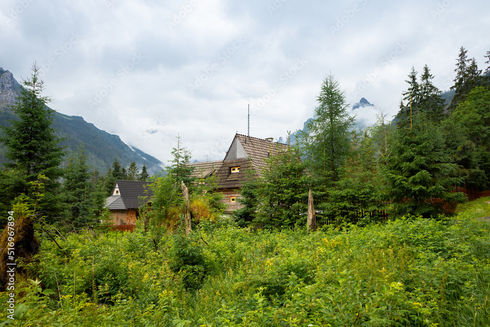 Old wooden house in the middle of the forest against the backdrop of mountains near the road to Morskie Oko Poland