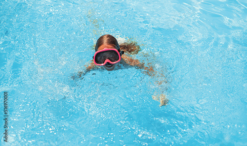 Child swims in pool underwater  happy active girl in snorkel goggles has fun in water