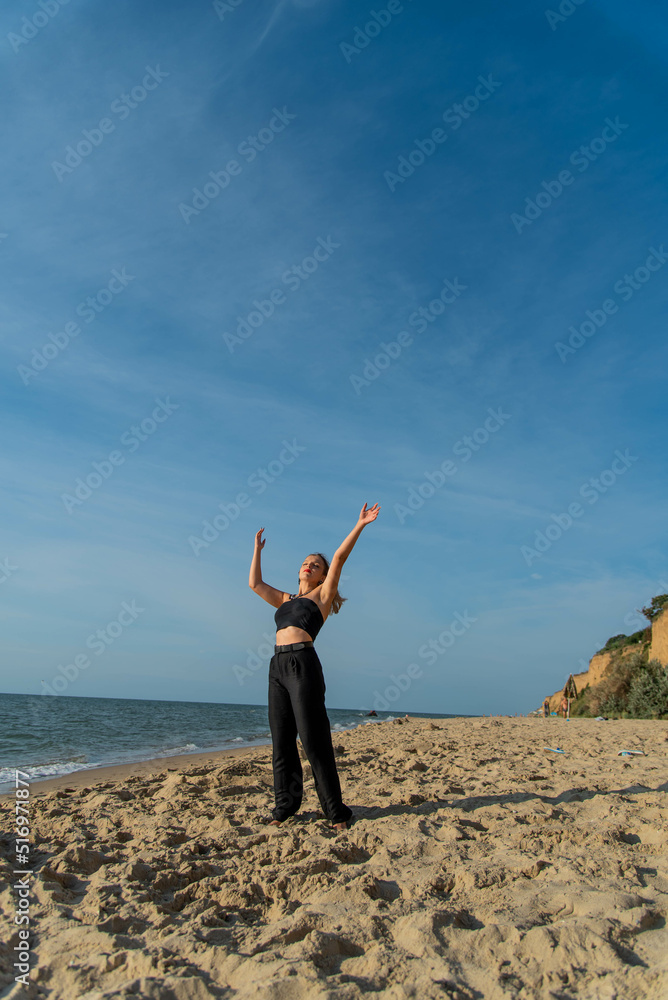 Woman wearing black dress walking on beach. See view Woman wearing black dress walking on beach. See view