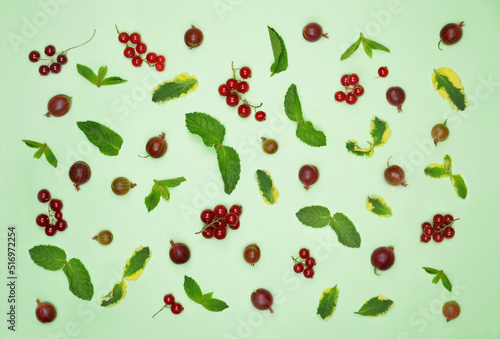 Background from summer berries and mint leaves. Berries set from ripe gooseberry red currents and mint leaves іisolated on light green background. Healthy vitamin dessert concept. Top view , flat lay
