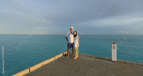 father and daughter taking pictures on the ocean