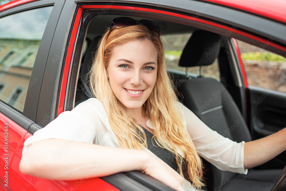 Beautiful blonde driving a car on the road.