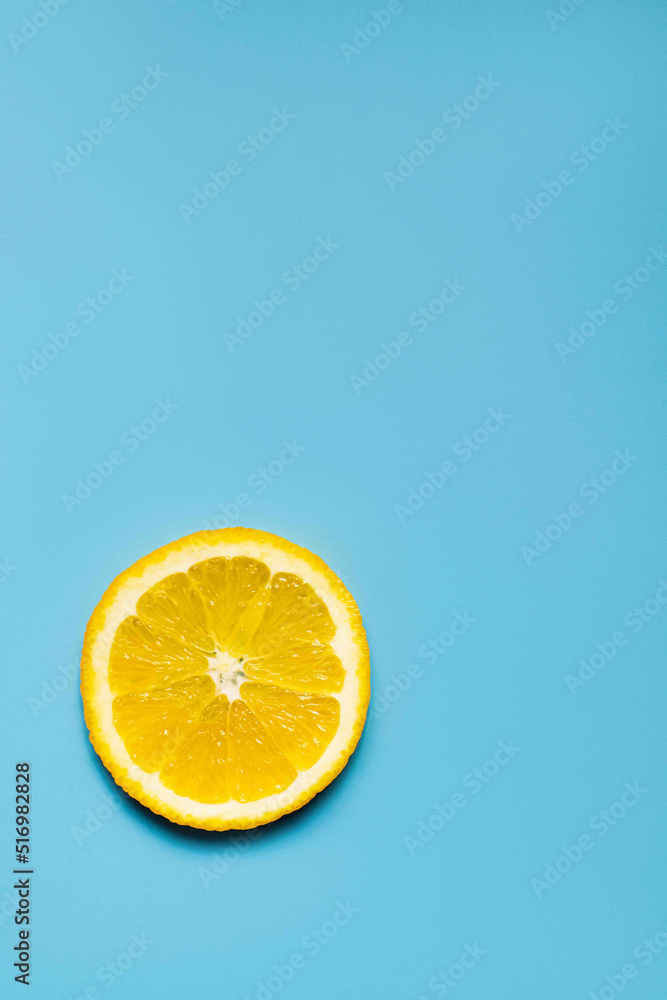 Top view of slice of sweet orange on blue surface with copy space. Top view of slice of sweet orange on blue surface with copy space.