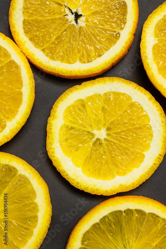 Close up view of slices of tropical oranges on black background.