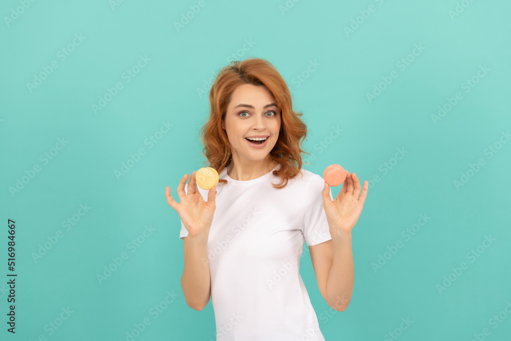 glad woman hold sweet macaron french cookie on blue background glad woman hold sweet macaron french cookie on blue background