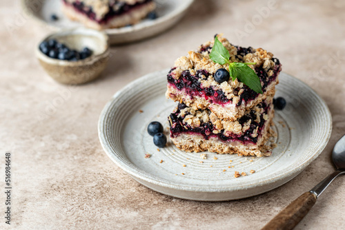 Canvastavla Homemade blueberry crumble bars on a plate decorated with mint on beige