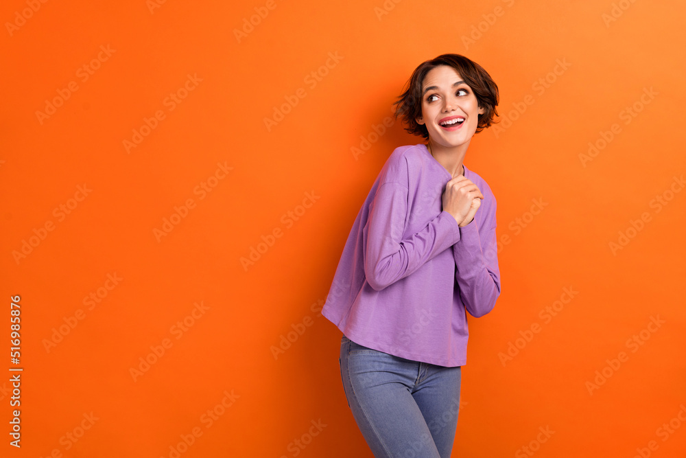 Obraz premium Photo of dreamy adorable girl dressed purple pullover looking empty space isolated orange color background