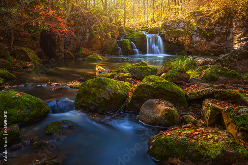 Autumn mountain waterfall. Forest in october