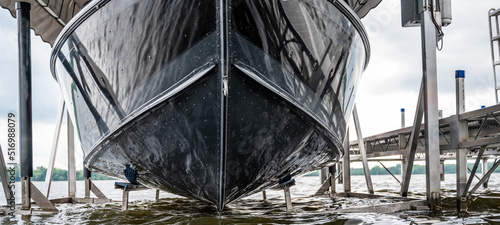 Boat with a hydraulic dock lift sitting above the water line on a lake.