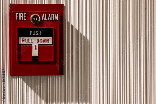 Selective focus on a wall mounted fire alarm switch in a empty hallway