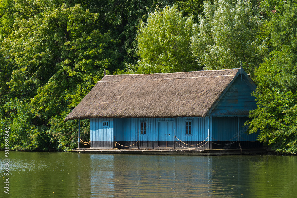 A Beautiful Lake House Bounded by the Green Forest on a Beautiful Summer Day A Beautiful Lake House Bounded by the Green Forest on a Beautiful Summer Day