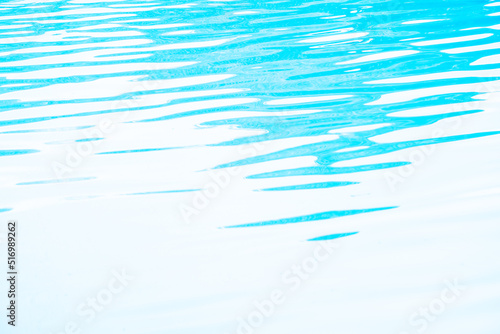 Blurred transparent blue colored clear calm water surface texture with splashes and bubbles. Trendy abstract nature background. Water waves in sunlight. water background