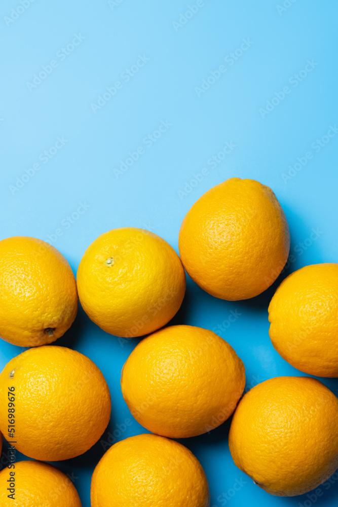 Top view of natural oranges on blue background with copy space. Top view of natural oranges on blue background with copy space.