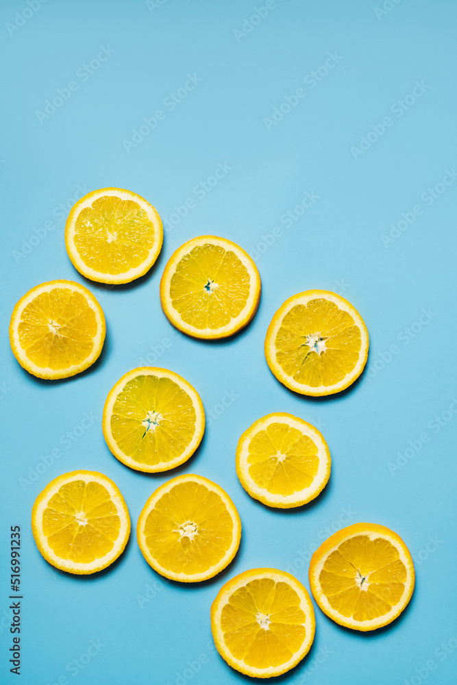 Top view of slices of sweet orange on blue background.