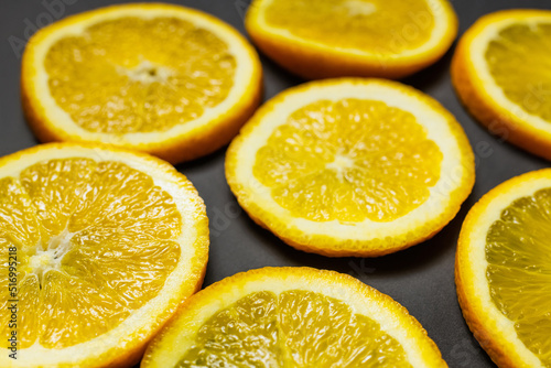 Close up view of bright slices of fresh oranges on black background.