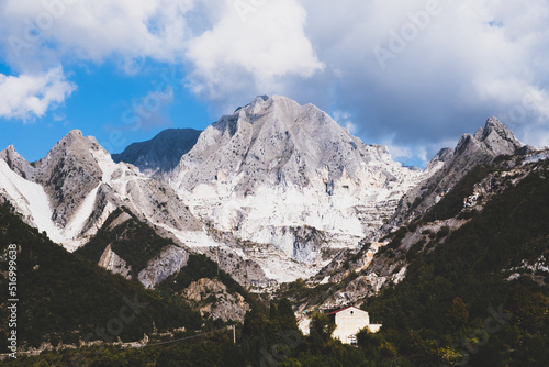 Marble quarry in Carrara, in Tuscany region, Italy. Famous location and place of interest. Mountain town view with white marble rock and blue sky.