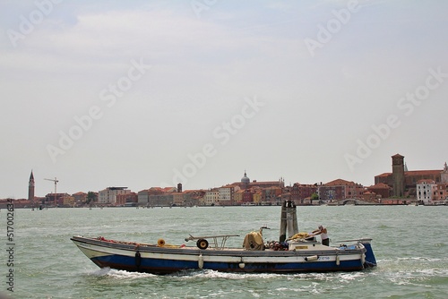 fishing boat in the background city of Chioggia, boat on the sea and city in the background, Italian fishing town, orange-red buildings, Italy, fisherman