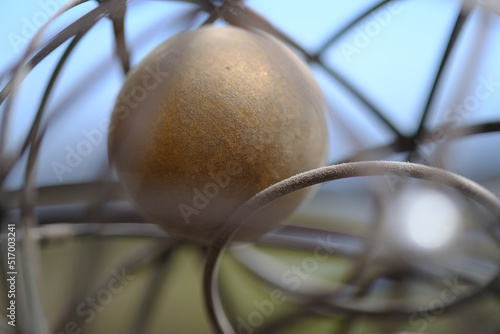 Closeup shots of brass and wire sphere with ball inside