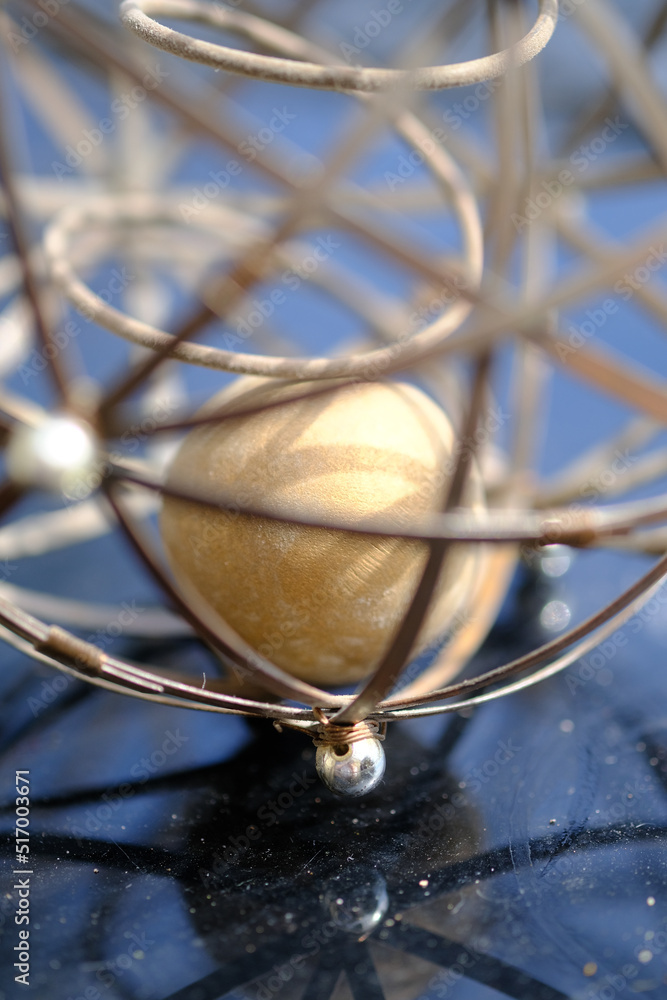 Closeup shots of brass and wire sphere with ball inside Closeup shots of brass and wire sphere with ball inside